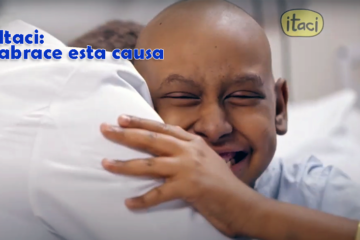 Imagem de uma criança sem cabelos, em tratamento contra o câncer, sorrindo abraçada ao seu médico