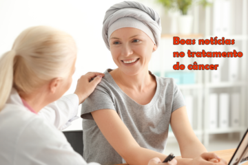 Imagem de uma médica colocando a mão esquerda sobre o ombro da sua paciente oncológica, que usa umm lenço cinza na cabeça e sorri para a médica