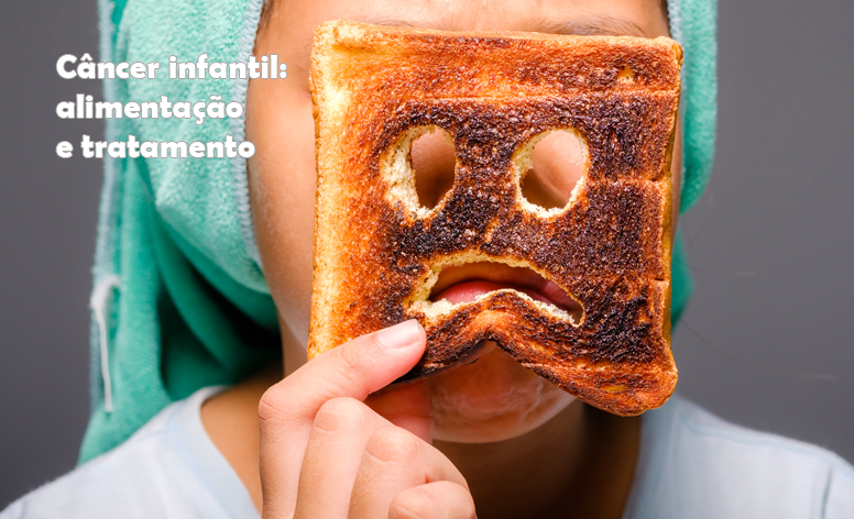 Foto de uma criança, com um lenço na cabeça, segurando uma fatia de pão com dois buracos feito olhos e outro feito uma boca triste