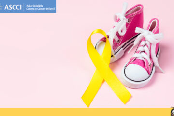 Imagem de um par de tênis all star infantil na cor rosa e de cano alto sobre ele um laço na cor amarela indicando o dia nacional de combate ao câncer infantojuvenil